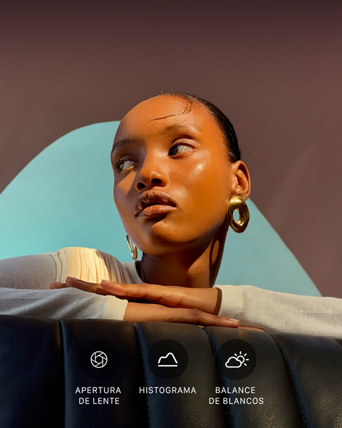Primer plano del retrato de una modelo bien iluminada con un fondo colorido, para mostrar la interfaz de los controles Pro del sistema de cámaras Pro: Apertura de Lente, Histograma, Balance de Blancos