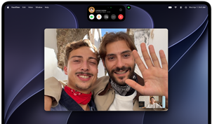 MacBook Pro con pantalla PROLED XDR, color plata, la pantalla muestra una videollamada en curso con dos personas en un pueblo a pleno sol saludando a una persona que está en casa