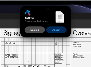 Una pantalla muestra la Dynamic Island con una solicitud de AirDrop en una ventana pequeña sobre un archivo de Adobe Acrobat abierto
