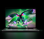 MacBook Pro con pantalla PROLED XDR, abierta, color plata, la pantalla muestra una imagen detallada, de alto contraste, con colores vívidos, la pantalla ilumina el teclado