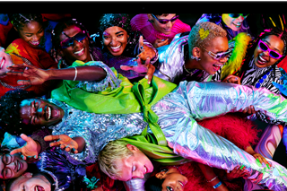 Imagen colorida de una persona en posición horizontal siendo sostenida por una multitud en una fiesta, destacando la brillante pantalla Liquid Retina XDR de la MacBook Pro