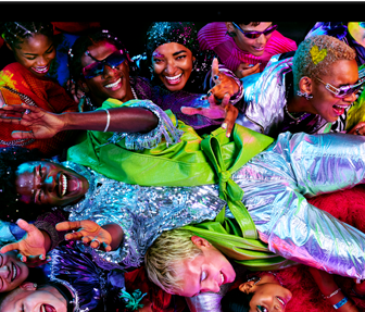 Imagen colorida de una persona en posición horizontal siendo sostenida por una multitud en una fiesta, destacando la brillante pantalla Liquid Retina XDR de la MacBook Pro